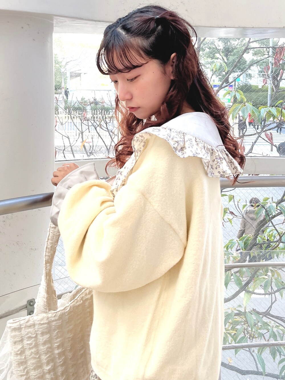 ブルー系のワンピース、ホワイト系のカーディガン/ボレロ、ホワイト系のトートバッグを着用したレディースの冬コーディネートの5枚目の写真