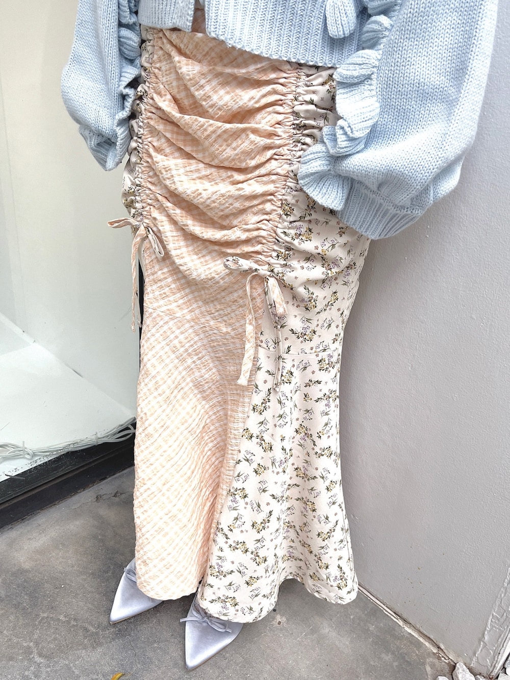 ホワイト系のニット/セーター、ブルー系のカーディガン/ボレロ、ホワイト系のスカートを着用したレディースの秋コーディネートの6枚目の写真