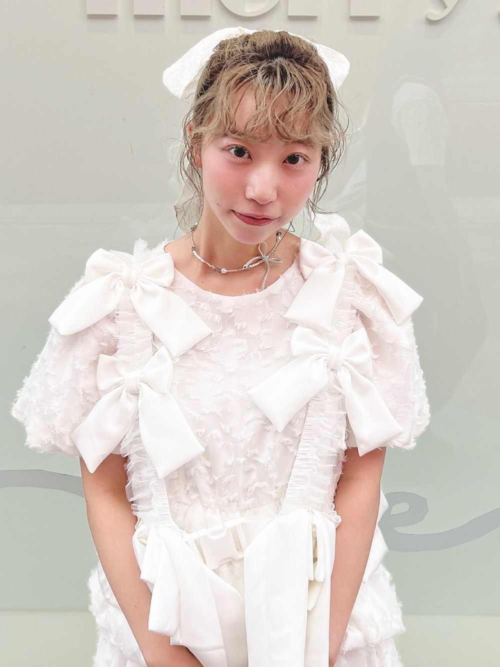 ホワイト系のワンピース、ピンク系のトートバッグ、ホワイト系のスニーカーを着用したレディースの夏コーディネートの4枚目の写真