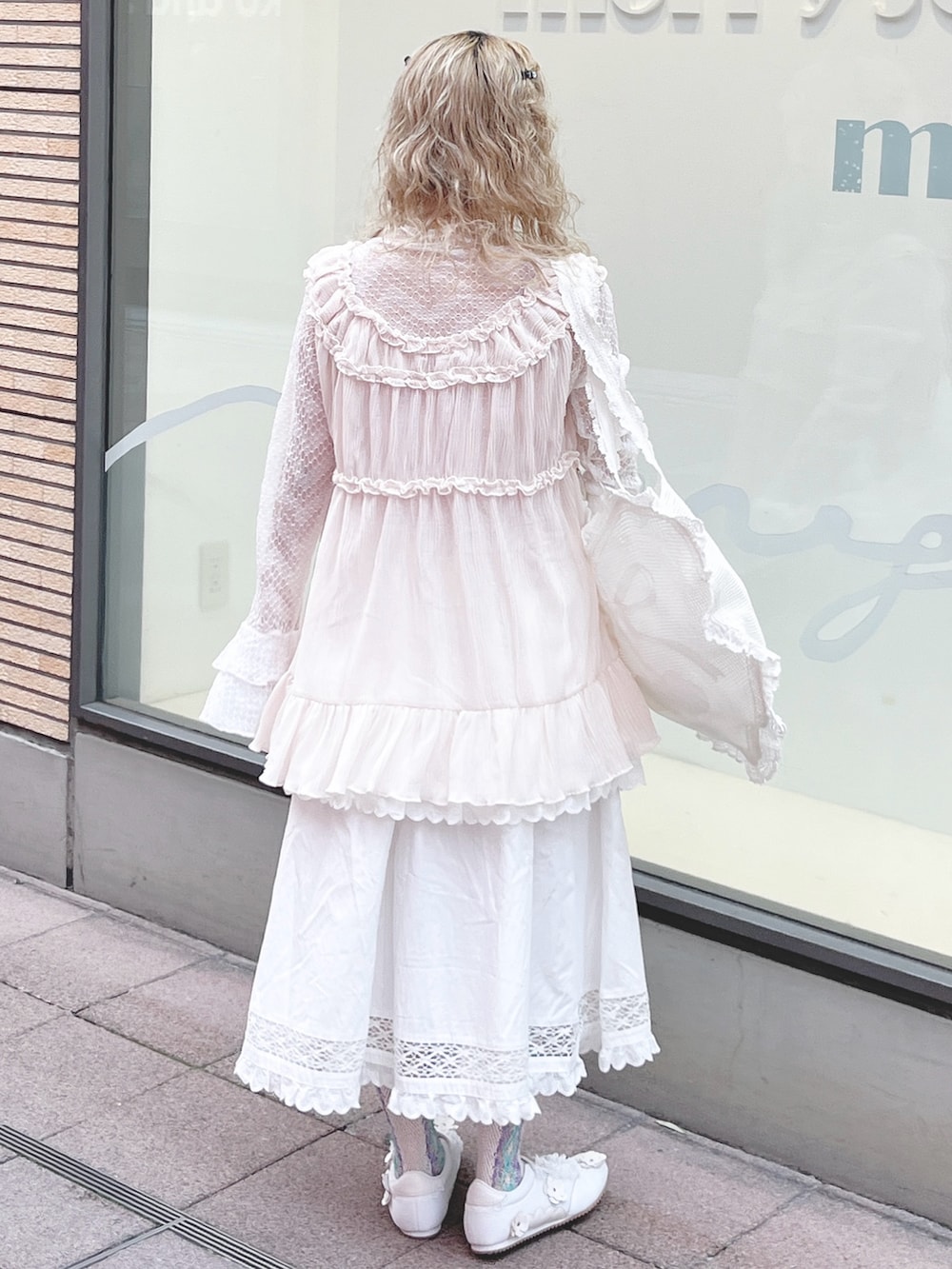 ホワイト系のTシャツ/カットソー、ホワイト系のトートバッグ、ホワイト系のスカートを着用したレディースの冬コーディネートの3枚目の写真