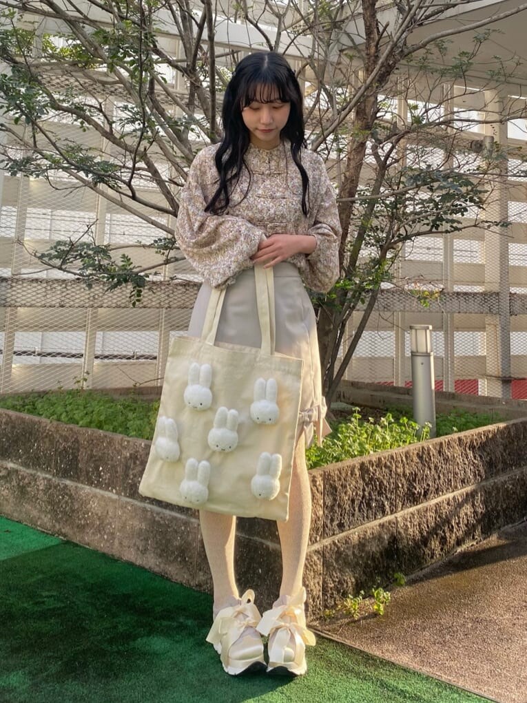 イエロー系のシャツ/ブラウス、ベージュ系のスカート、ホワイト系のスニーカーを着用したレディースの冬コーディネートの2枚目の写真