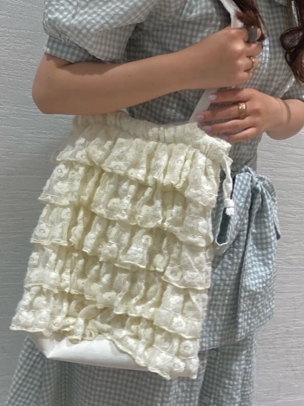 ホワイト系のサンダル、ホワイト系のトートバッグ、グリーン系のワンピースを着用したレディースの春コーディネートの6枚目の写真