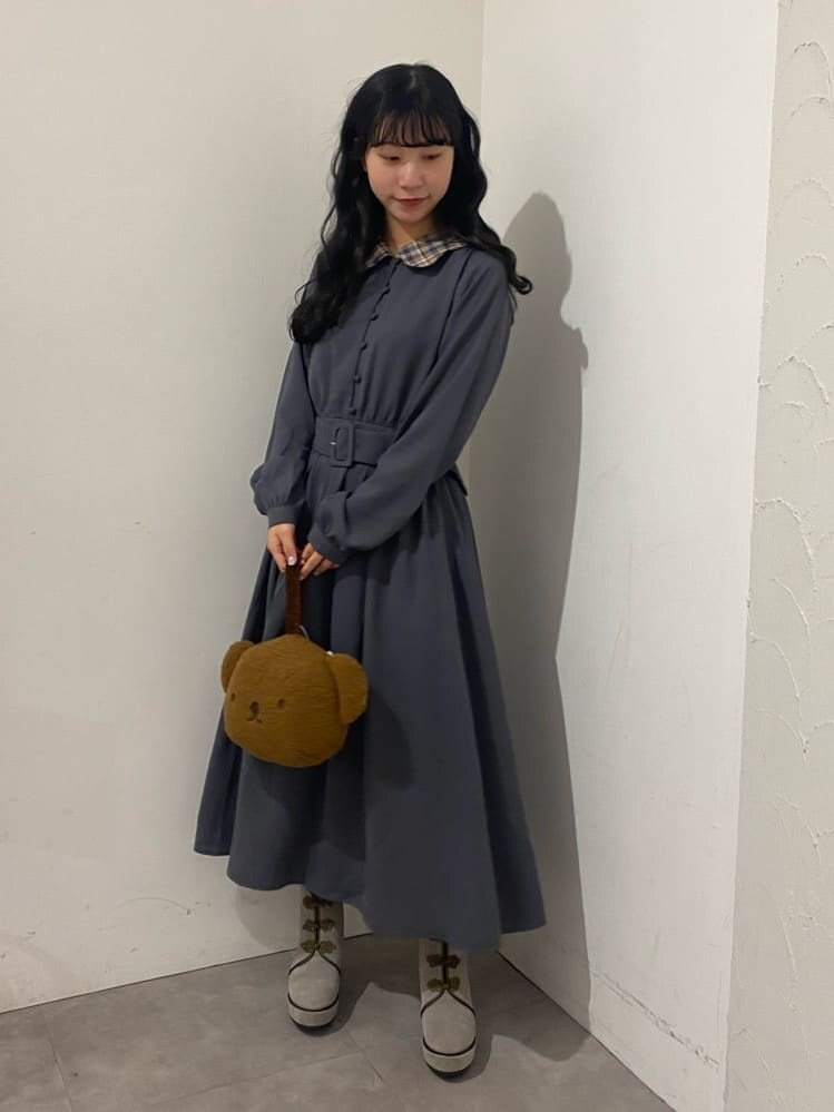 ベージュ系のブーツ、ブラウン系のハンドバッグ、ブルー系のワンピースを着用したレディースの秋コーディネートの2枚目の写真