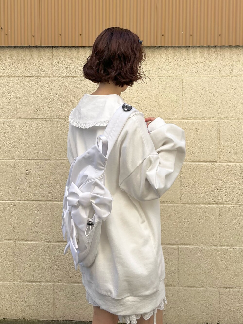 ホワイト系のシャツ/ブラウス、ホワイト系のスウェット、ホワイト系のショルダーバッグを着用したレディースの冬コーディネートの3枚目の写真