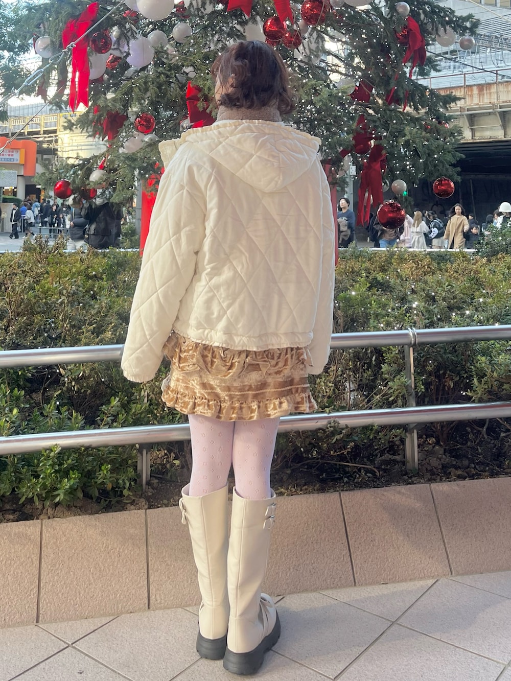 ホワイト系のカーディガン/ボレロ、ホワイト系のダウンジャケット/コート、ブラウン系のスカートを着用したレディースの冬コーディネートの2枚目の写真