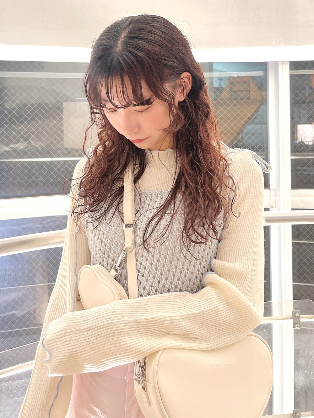 シルバー系のキャミソール、ホワイト系のTシャツ/カットソー、ホワイト系のショルダーバッグを着用したレディースの冬コーディネートの4枚目の写真