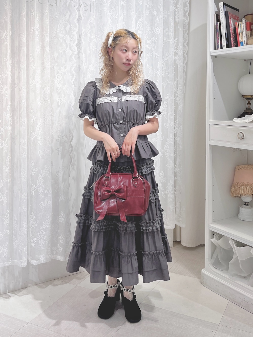 グレー系のシャツ/ブラウス、グレー系のスカート、レッド系のハンドバッグを着用したレディースの夏コーディネートの2枚目の写真