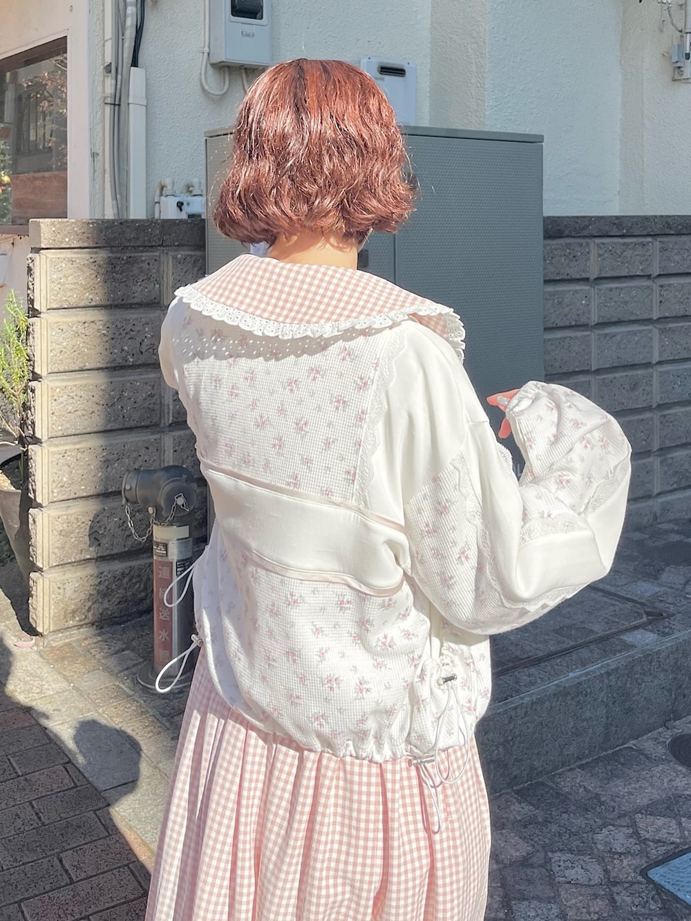 ピンク系のワンピース、ピンク系のジャージ、ホワイト系のスニーカーを着用したレディースの冬コーディネートの5枚目の写真