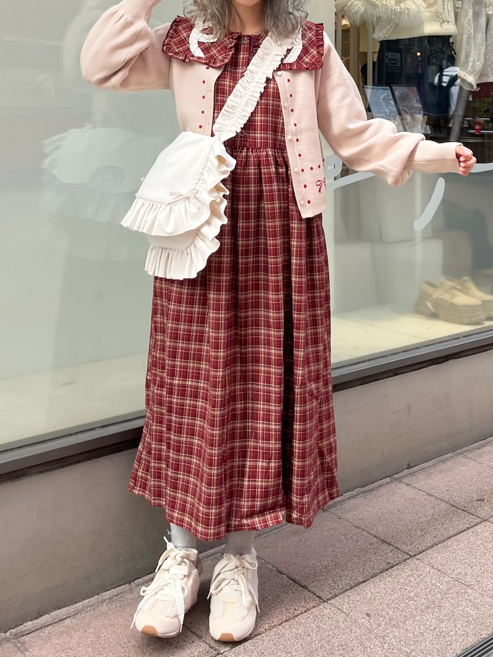 レッド系のワンピース、ホワイト系のカーディガン/ボレロ、ホワイト系のショルダーバッグを着用したレディースの秋コーディネートの4枚目の写真