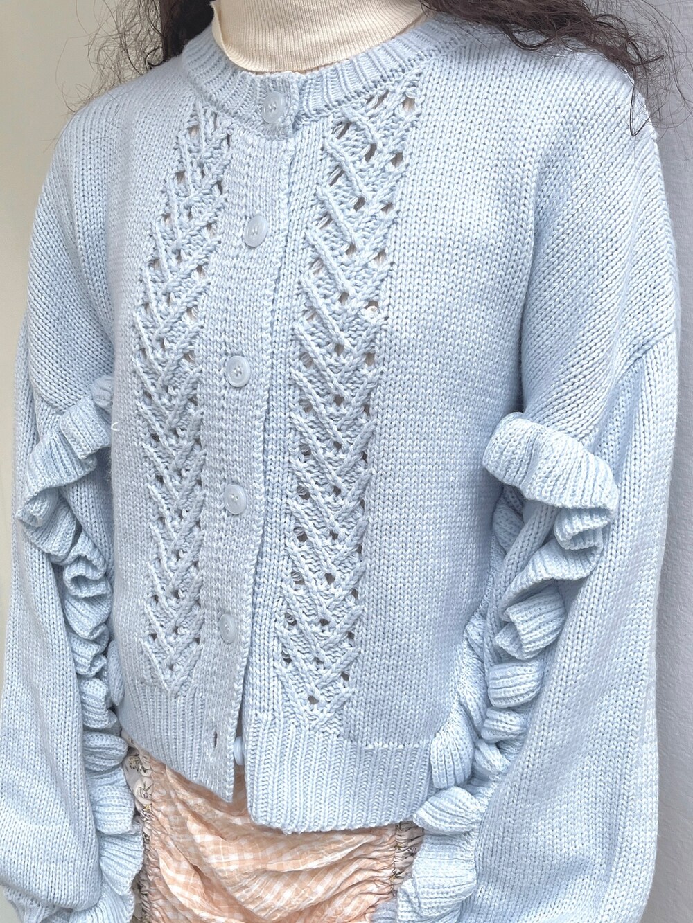 ホワイト系のニット/セーター、ブルー系のカーディガン/ボレロ、ホワイト系のスカートを着用したレディースの秋コーディネートの5枚目の写真