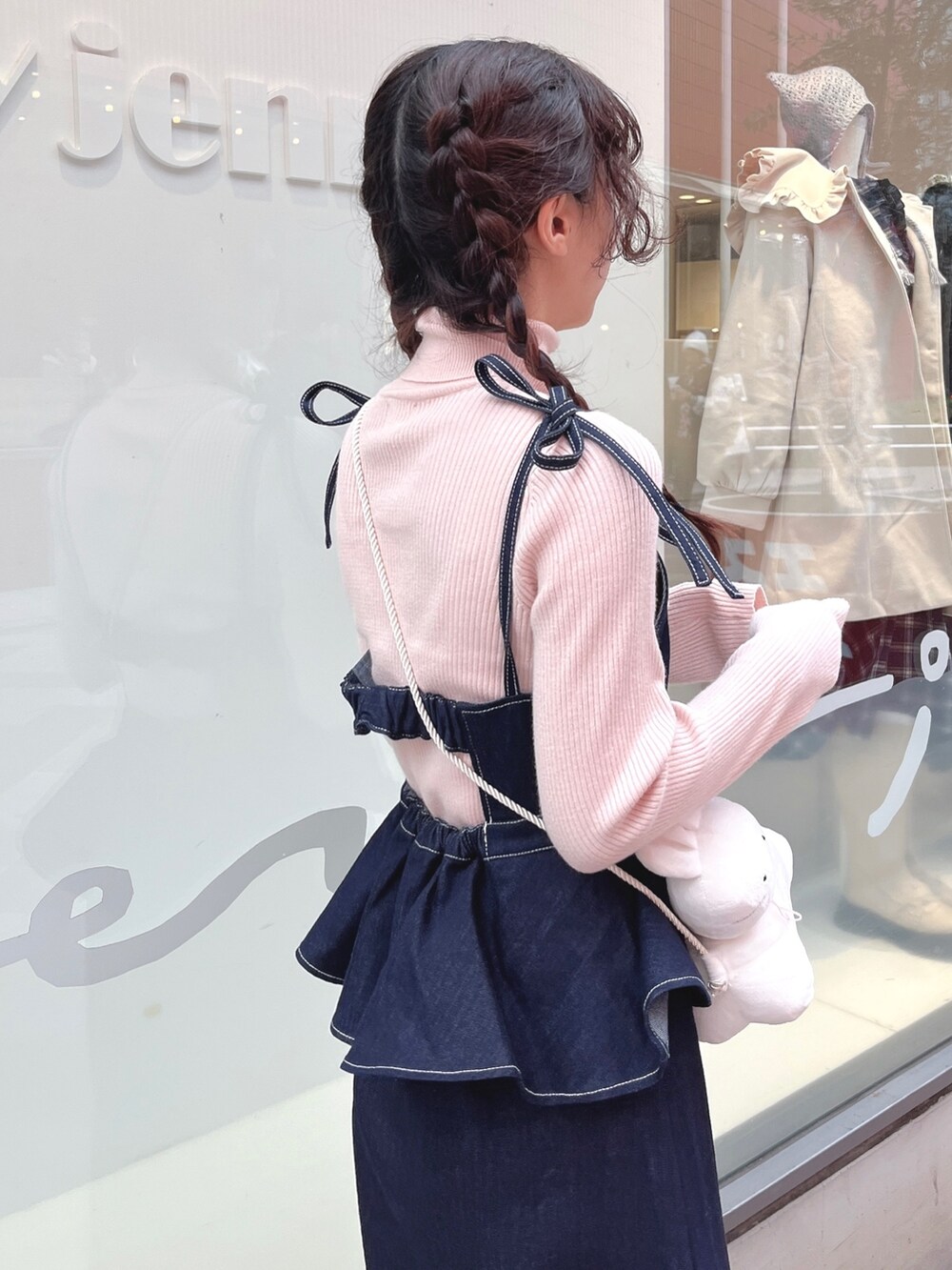 ピンク系のニット/セーター、ブルー系のワンピース、ホワイト系のショルダーバッグを着用したレディースの冬コーディネートの6枚目の写真