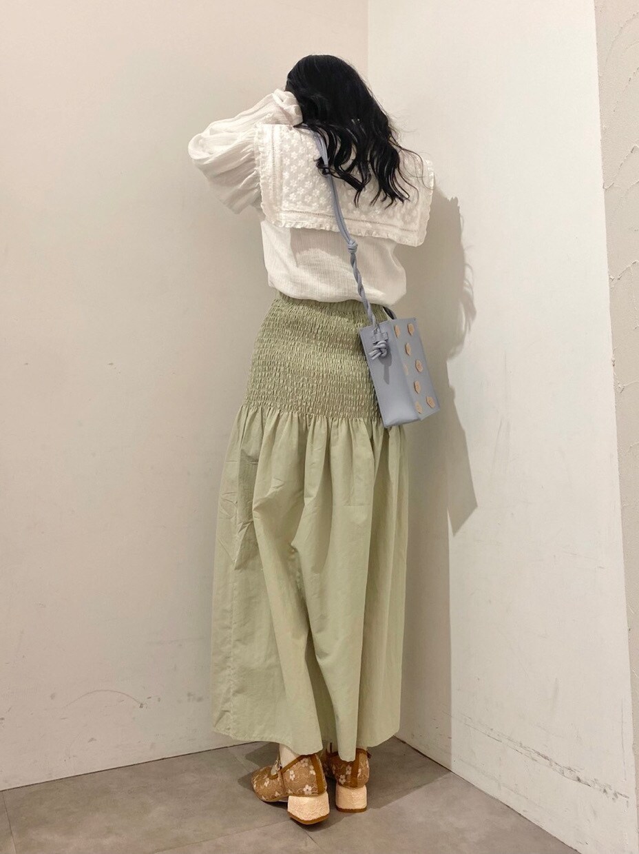 ホワイト系のシャツ/ブラウス、グリーン系のスカート、ブルー系のショルダーバッグを着用したレディースの冬コーディネートの2枚目の写真