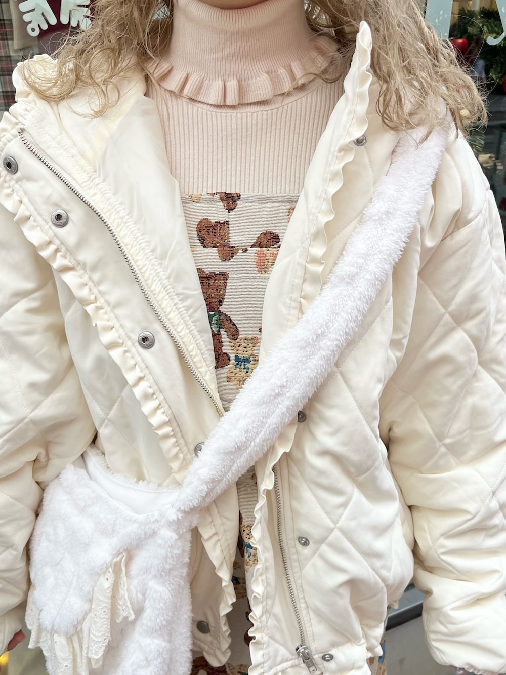 ホワイト系のダウンジャケット/コート、ホワイト系のショルダーバッグ、ホワイト系のニット/セーターを着用したレディースの冬コーディネートの8枚目の写真