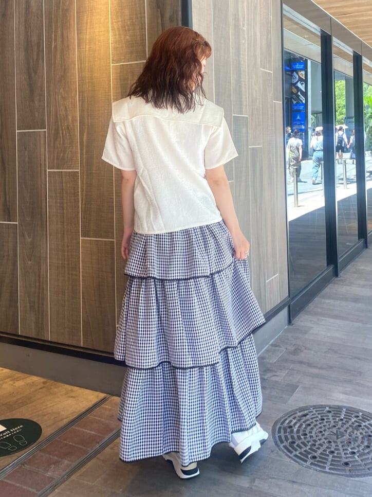 ホワイト系のスニーカー、ブラック系のスカート、ホワイト系のシャツ/ブラウスを着用したレディースの夏コーディネートの3枚目の写真