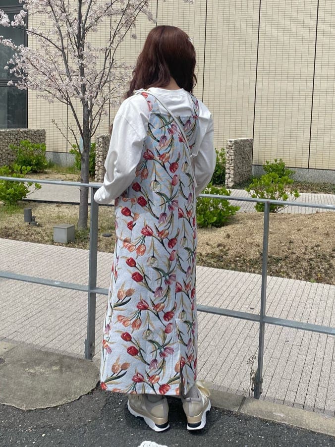 ブルー系のジャンパースカート、ホワイト系のスニーカー、ホワイト系のTシャツ/カットソーを着用したレディースの春コーディネートの3枚目の写真