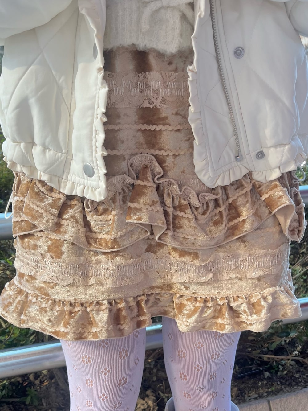 ホワイト系のカーディガン/ボレロ、ホワイト系のダウンジャケット/コート、ブラウン系のスカートを着用したレディースの冬コーディネートの7枚目の写真