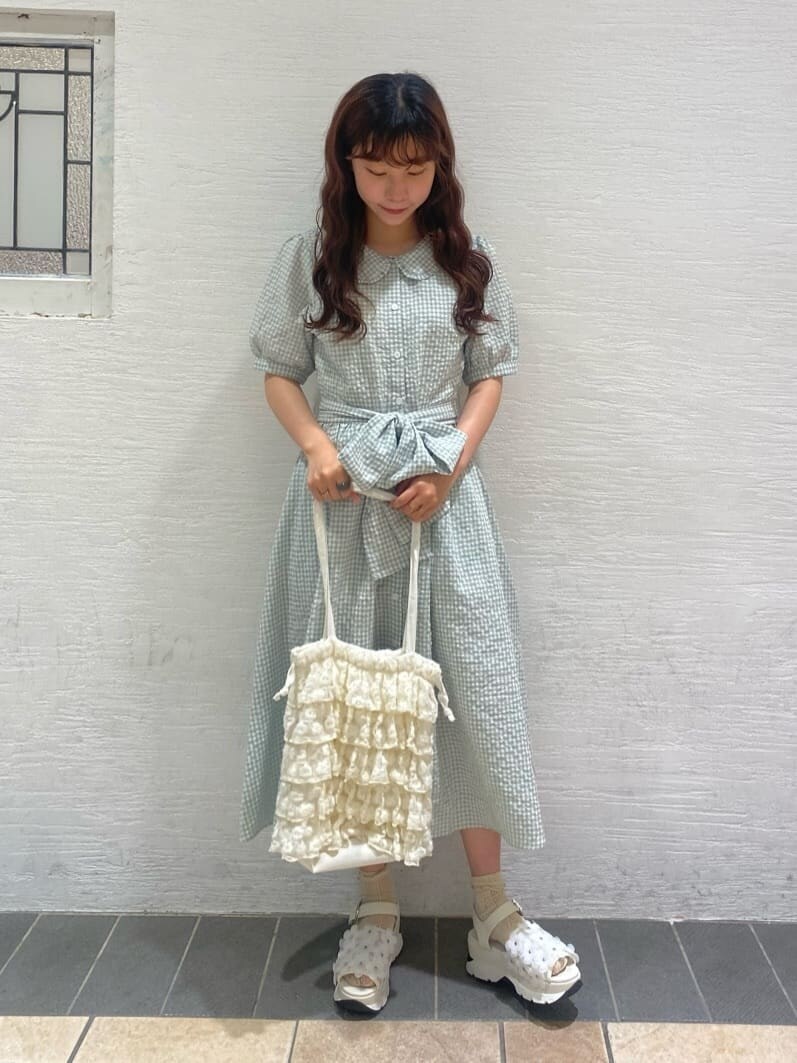 ホワイト系のサンダル、ホワイト系のトートバッグ、グリーン系のワンピースを着用したレディースの春コーディネートの2枚目の写真