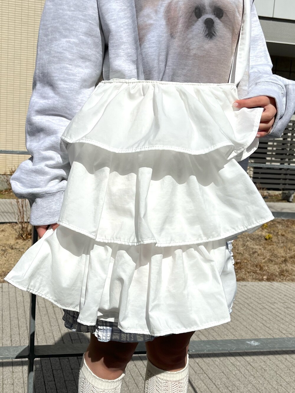 ホワイト系のパンプス、グレー系のスウェット、ホワイト系のシャツ/ブラウスを着用したレディースの冬コーディネートの5枚目の写真