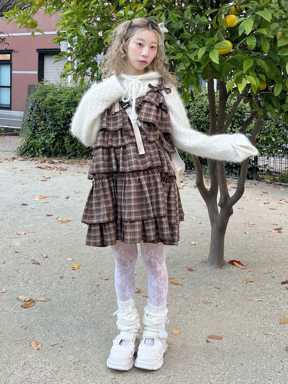 ホワイト系のニット/セーター、ブラウン系のワンピース、ベージュ系のショルダーバッグを着用したレディースの秋コーディネートの3枚目の写真