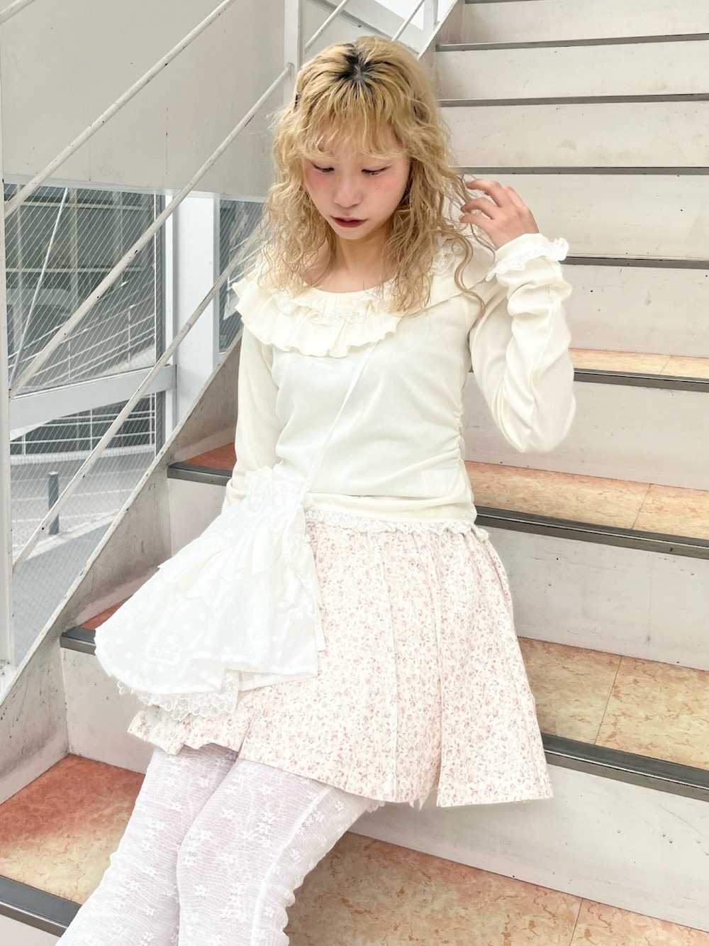 ホワイト系のTシャツ/カットソー、ホワイト系のショルダーバッグ、ピンク系のスカートを着用したレディースの冬コーディネートの6枚目の写真