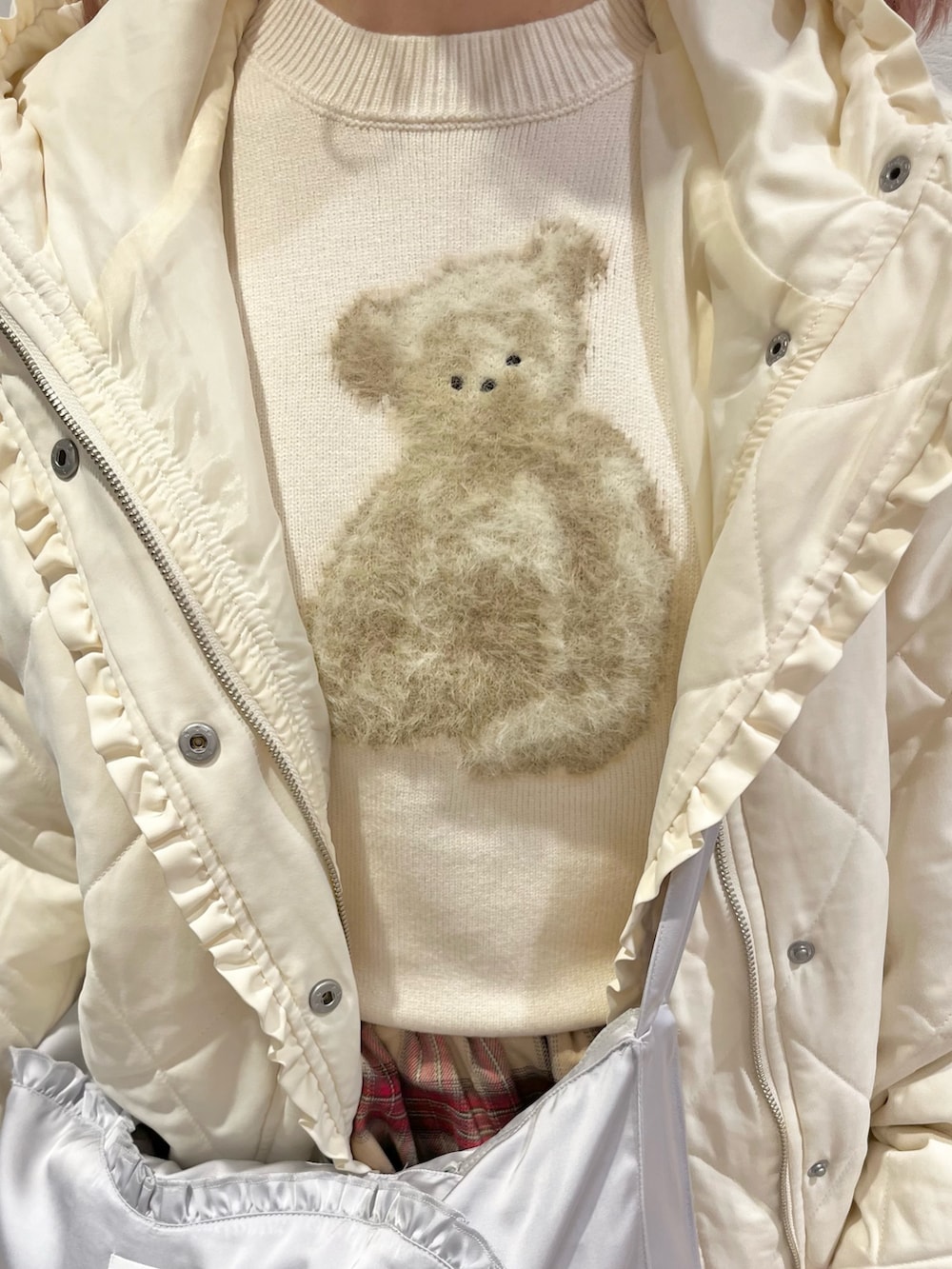 ホワイト系のダウンジャケット/コート、ホワイト系のニット/セーター、ブルー系のショルダーバッグを着用したレディースの冬コーディネートの7枚目の写真