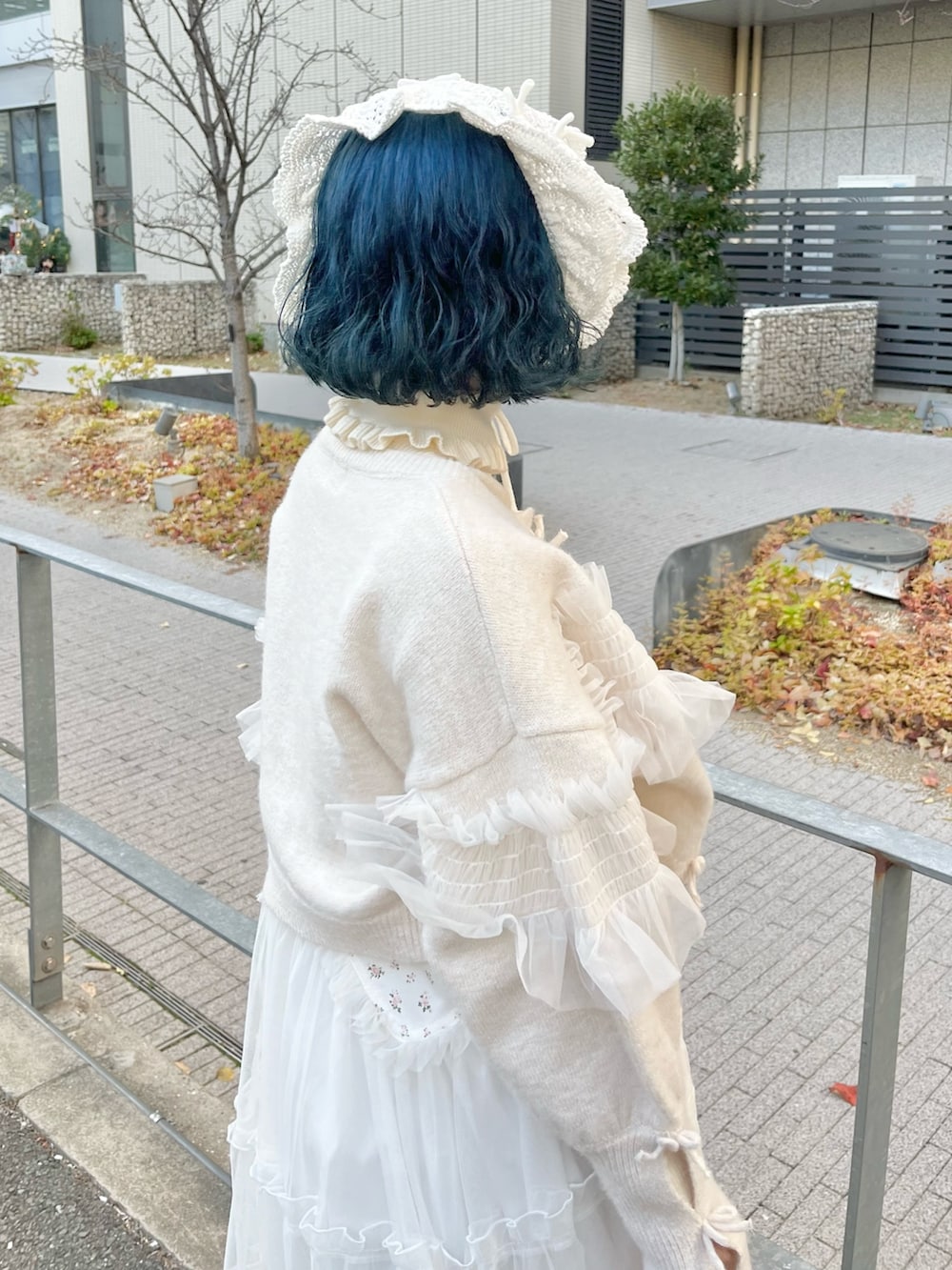 ホワイト系のニット/セーター、ホワイト系のカーディガン/ボレロ、ホワイト系のワンピースを着用したレディースの冬コーディネートの8枚目の写真