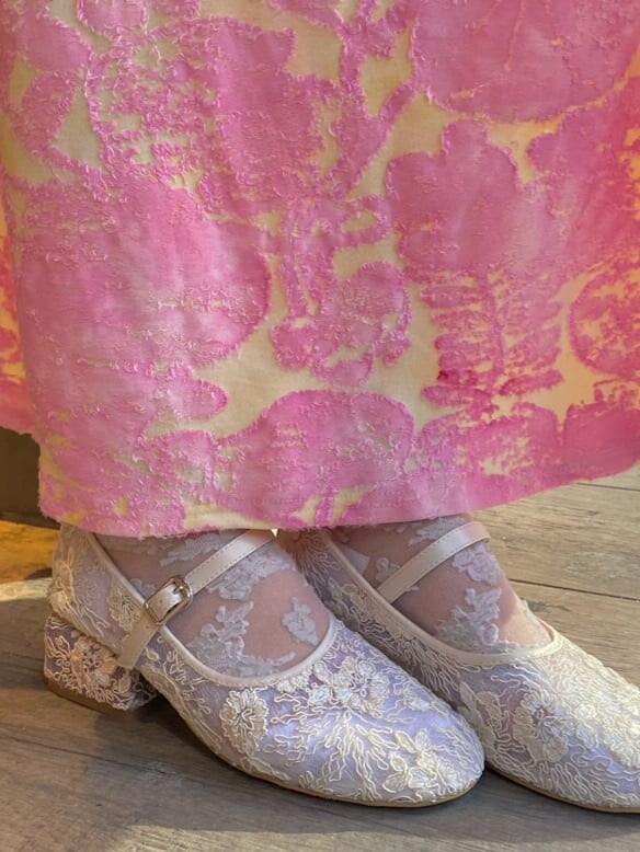 ピンク系のワンピース、ホワイト系のカーディガン/ボレロ、ホワイト系のパンプスを着用したレディースの冬コーディネートの5枚目の写真