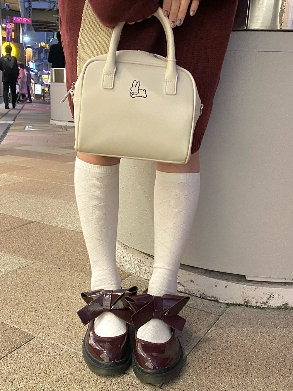 レッド系のワンピース、ホワイト系のボストンバッグ、レッド系のその他シューズを着用したレディースの秋コーディネートの4枚目の写真