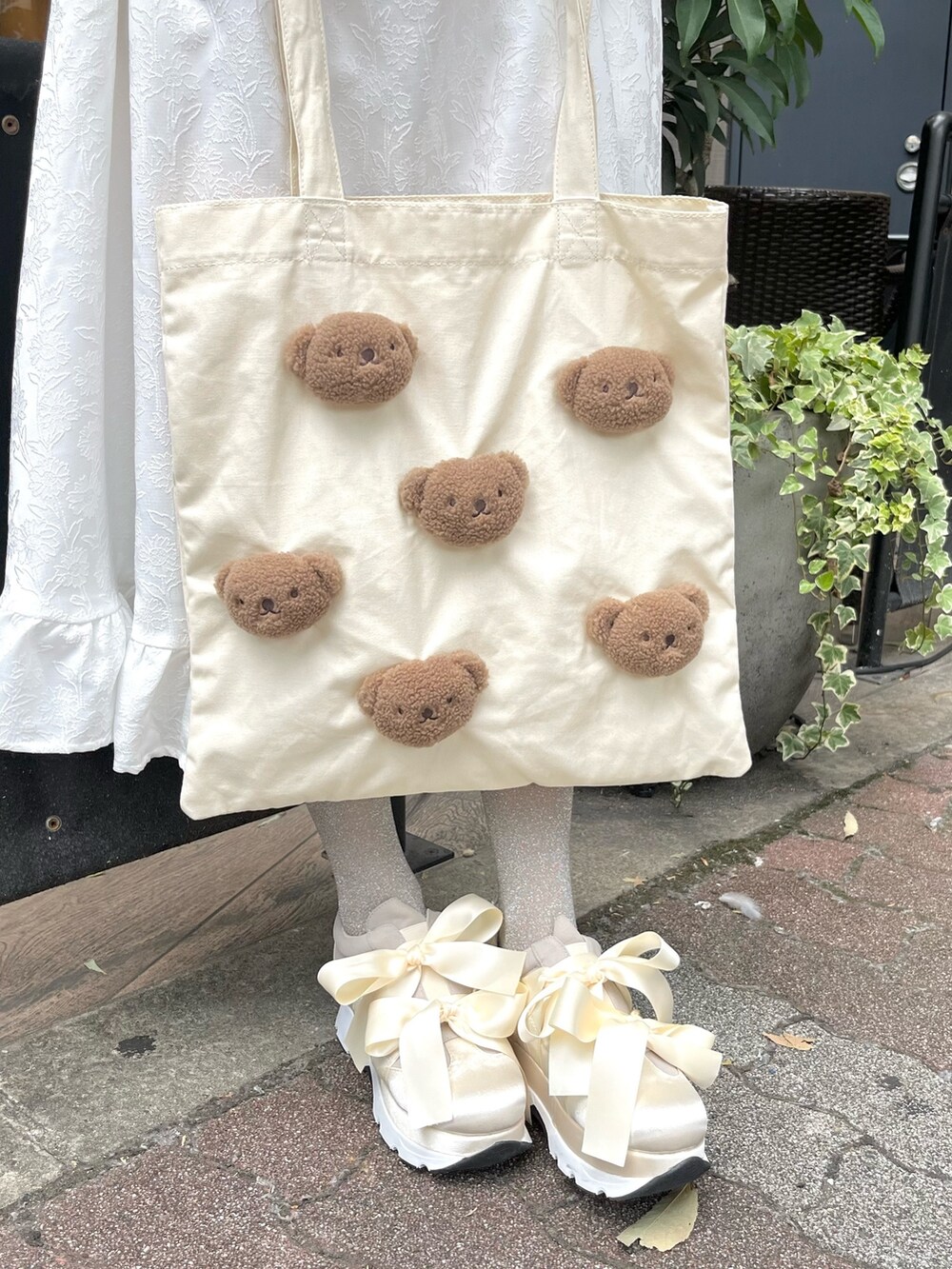 ホワイト系のスニーカー、ホワイト系のワンピース、ホワイト系のトートバッグを着用したレディースの夏コーディネートの7枚目の写真