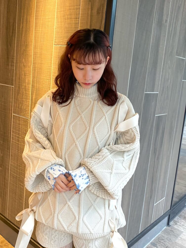 ホワイト系のニット/セーター、ホワイト系のブーツ、ブルー系のチュニックを着用したレディースの秋コーディネートの4枚目の写真