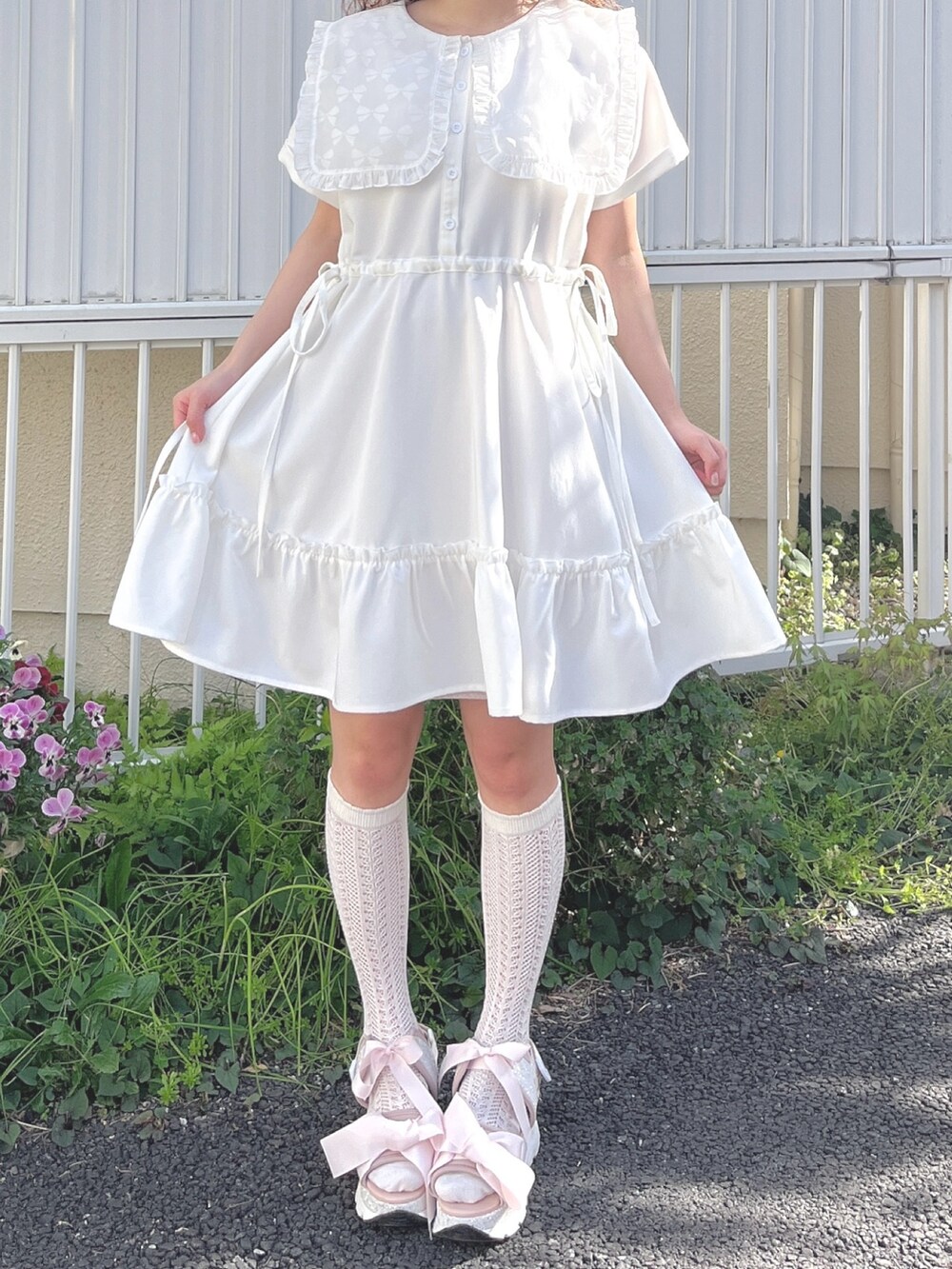 ホワイト系のワンピース、ピンク系のサンダルを着用したレディースの春コーディネートの4枚目の写真