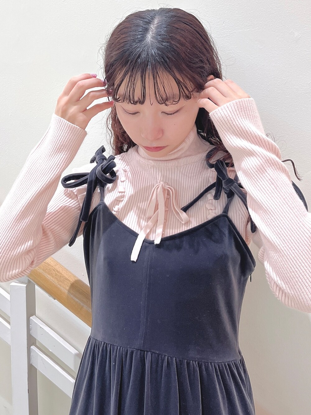 ピンク系のニット/セーター、グレー系のワンピース、ホワイト系のパンプスを着用したレディースの冬コーディネートの4枚目の写真