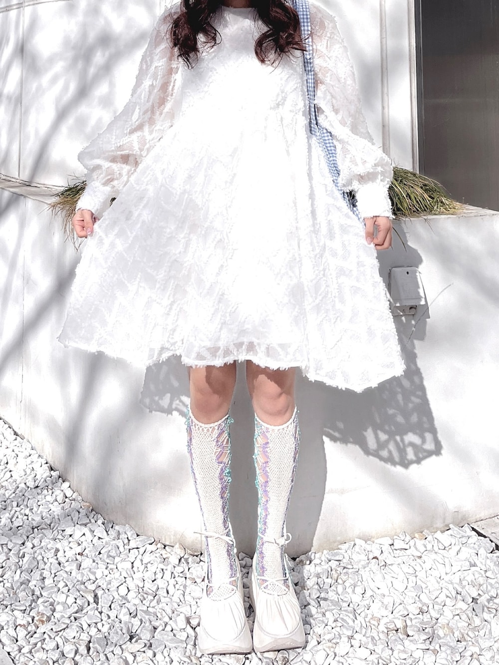 ホワイト系のワンピース、ブルー系のトートバッグ、ホワイト系のバレエシューズを着用したレディースの冬コーディネートの6枚目の写真