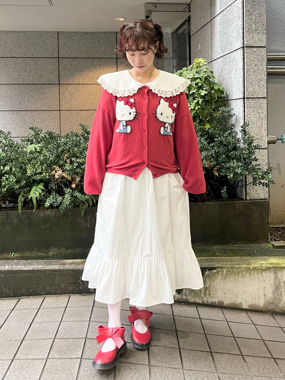 レッド系のカーディガン/ボレロ、ホワイト系のワンピース、レッド系のバレエシューズを着用したレディースの秋コーディネートの5枚目の写真