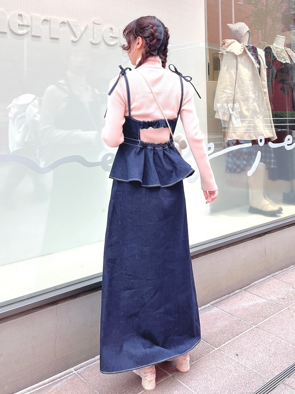 ピンク系のニット/セーター、ブルー系のワンピース、ホワイト系のショルダーバッグを着用したレディースの冬コーディネートの4枚目の写真