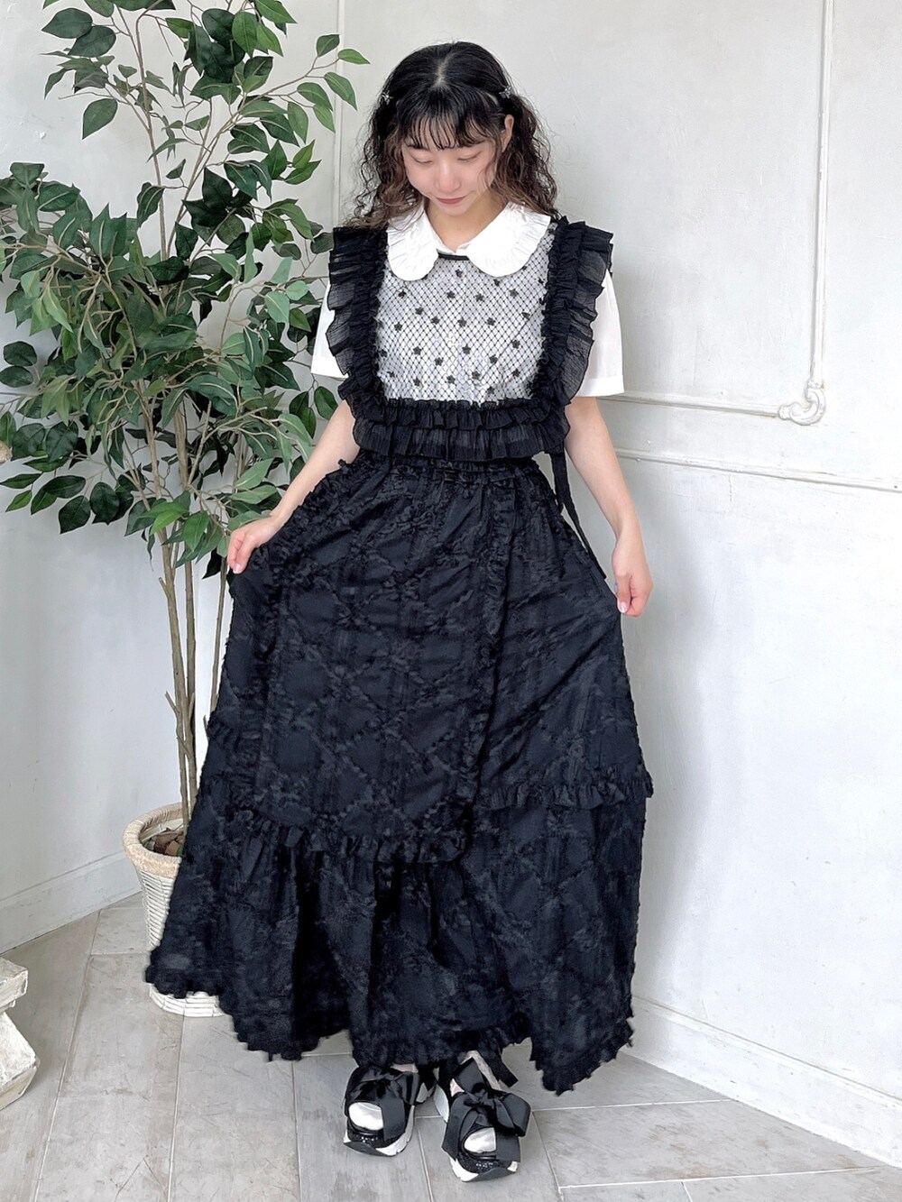 ホワイト系のシャツ/ブラウス、ブラック系のスカート、ブラック系のサンダルを着用したレディースの春コーディネートの2枚目の写真