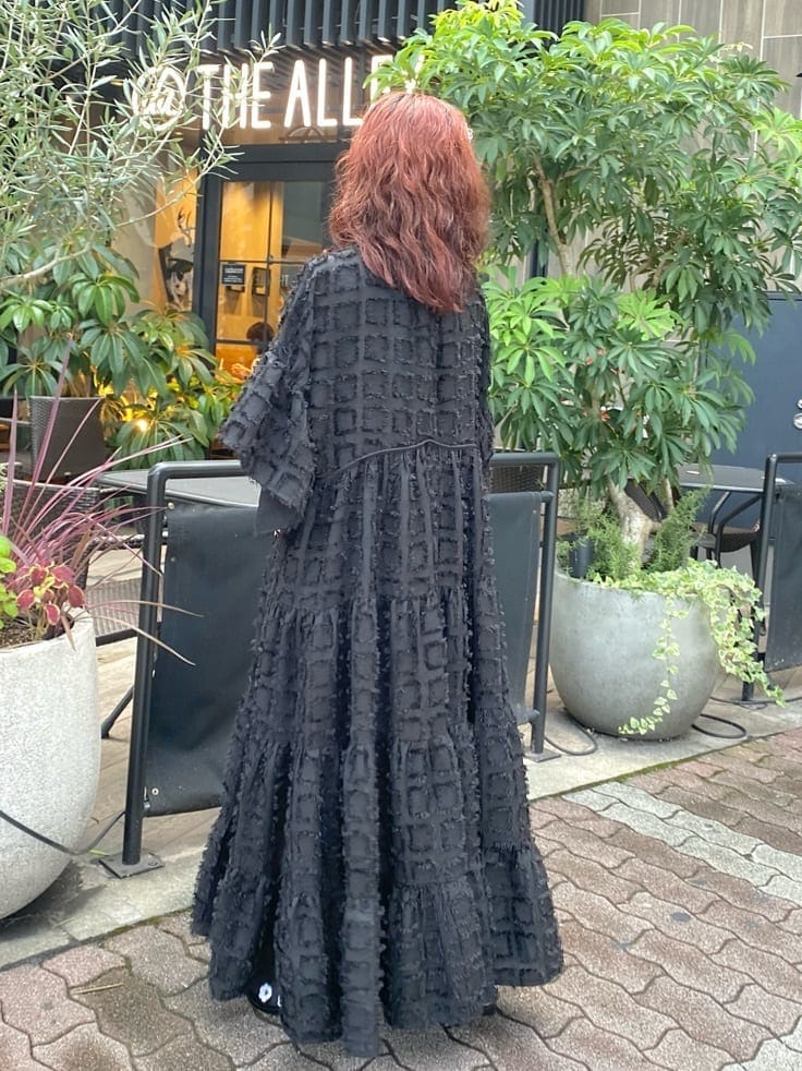 ブラック系のワンピース、ブラック系のパンプス、その他のハンドバッグを着用したレディースの秋コーディネートの2枚目の写真