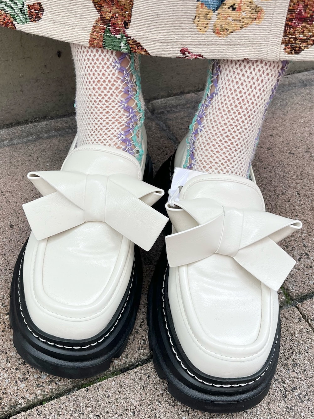 ホワイト系のダウンジャケット/コート、ホワイト系のショルダーバッグ、ホワイト系のニット/セーターを着用したレディースの冬コーディネートの10枚目の写真