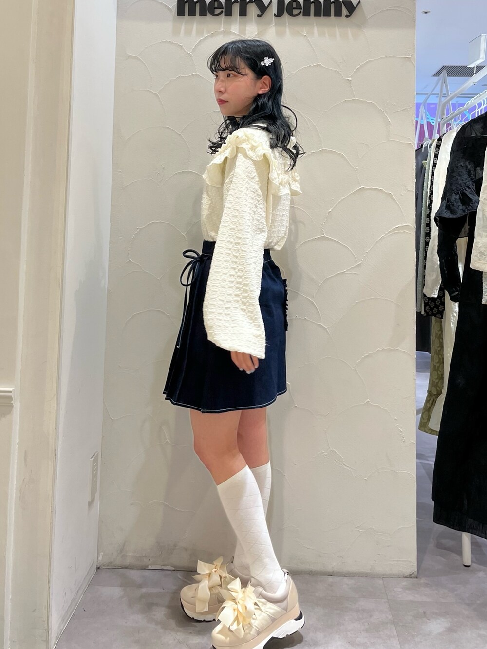 ブルー系のデニムスカート、ホワイト系のTシャツ/カットソー、ホワイト系のスニーカーを着用したレディースの冬コーディネートの3枚目の写真