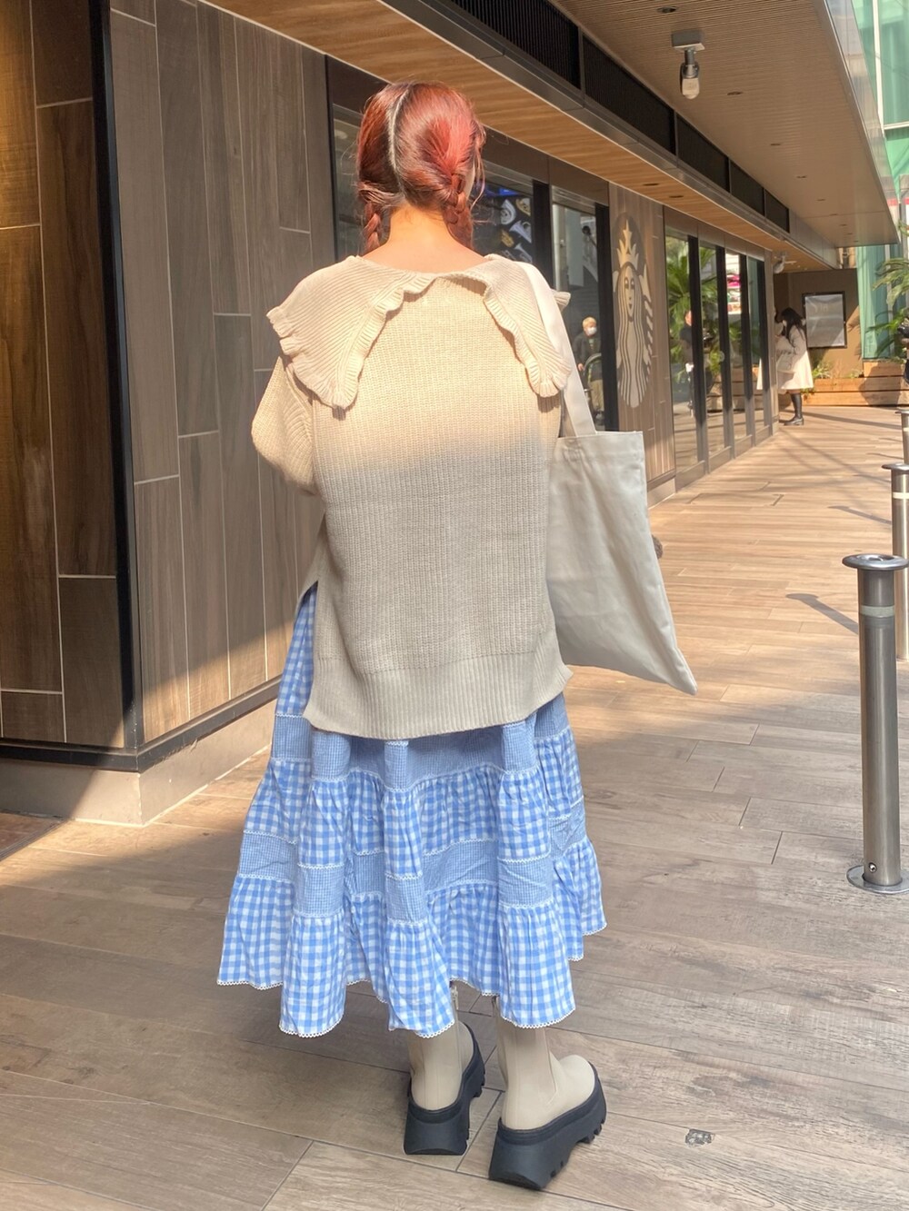 ホワイト系のニット/セーター、ホワイト系のトートバッグ、ブルー系のスカートを着用したレディースの冬コーディネートの3枚目の写真