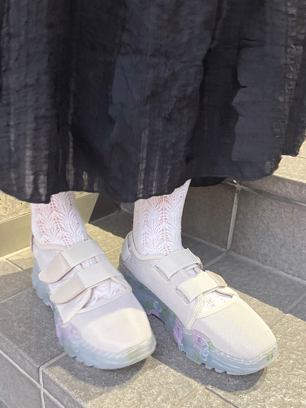 ホワイト系のTシャツ/カットソー、ブラック系のスカート、ベージュ系のスニーカーを着用したレディースの夏コーディネートの5枚目の写真