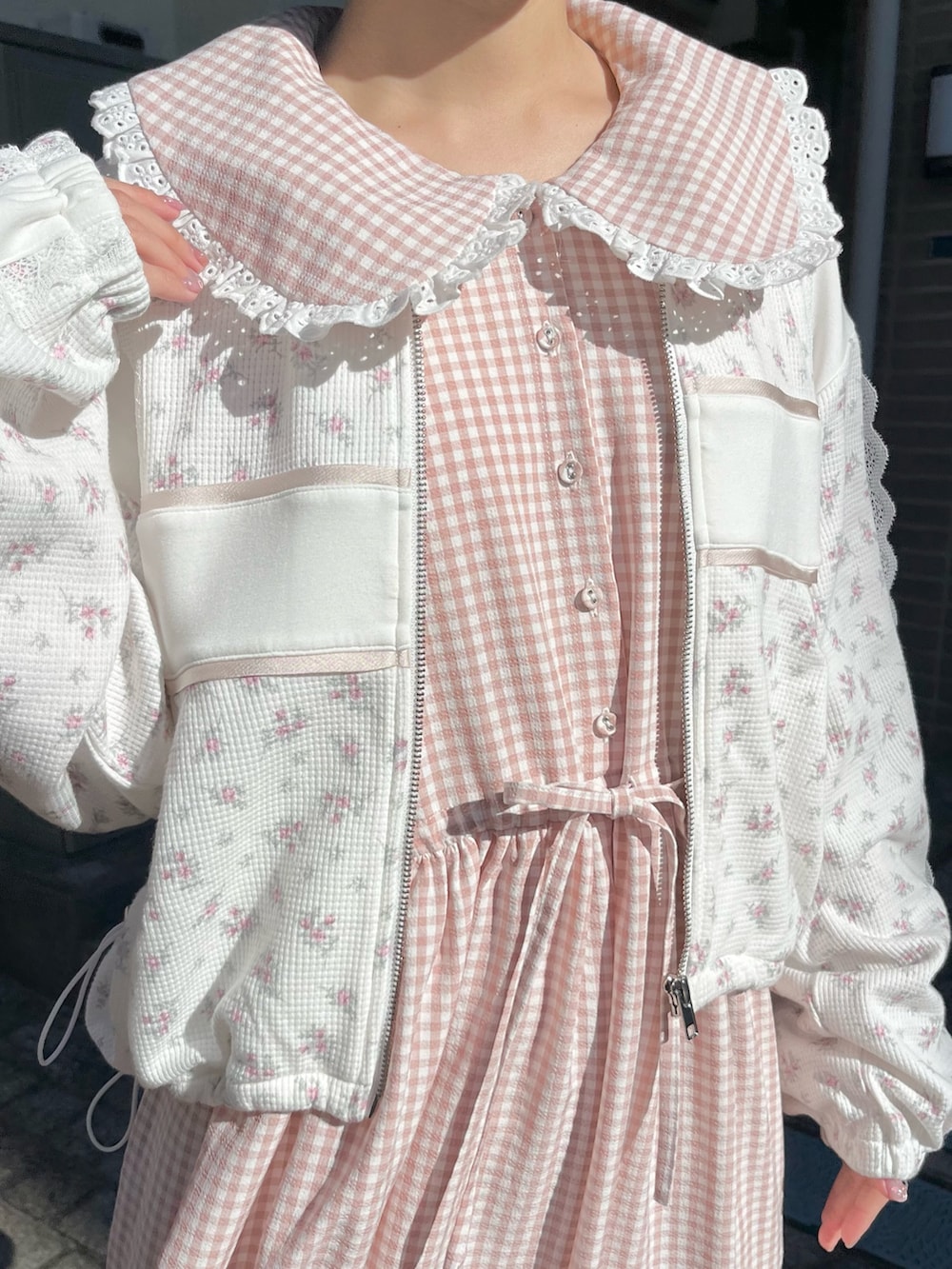 ピンク系のワンピース、ピンク系のジャージ、ホワイト系のスニーカーを着用したレディースの冬コーディネートの6枚目の写真