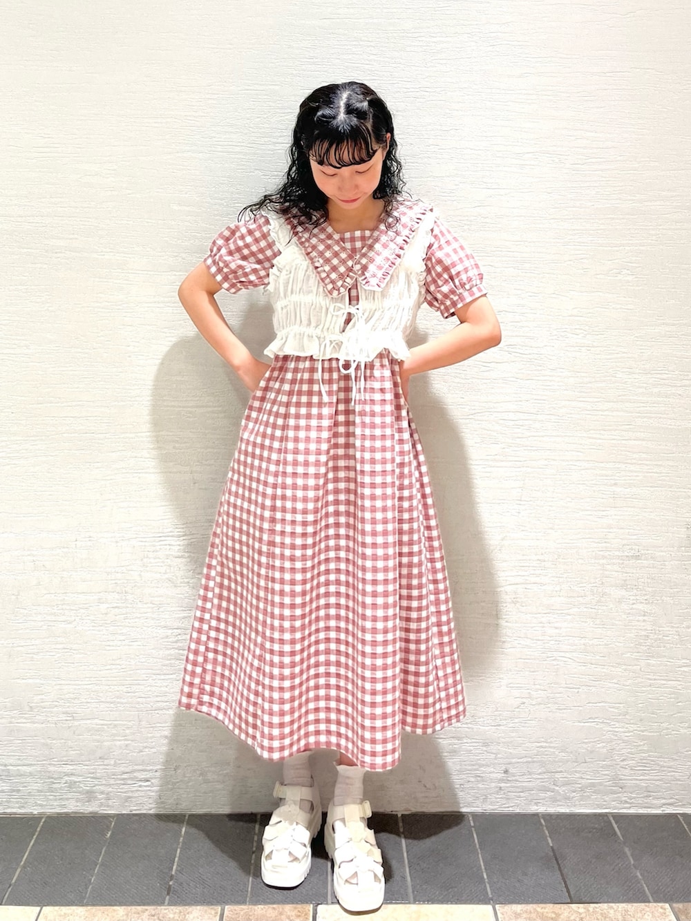 ピンク系のワンピース、ホワイト系のサンダル、ホワイト系のベストを着用したレディースの夏コーディネートの2枚目の写真