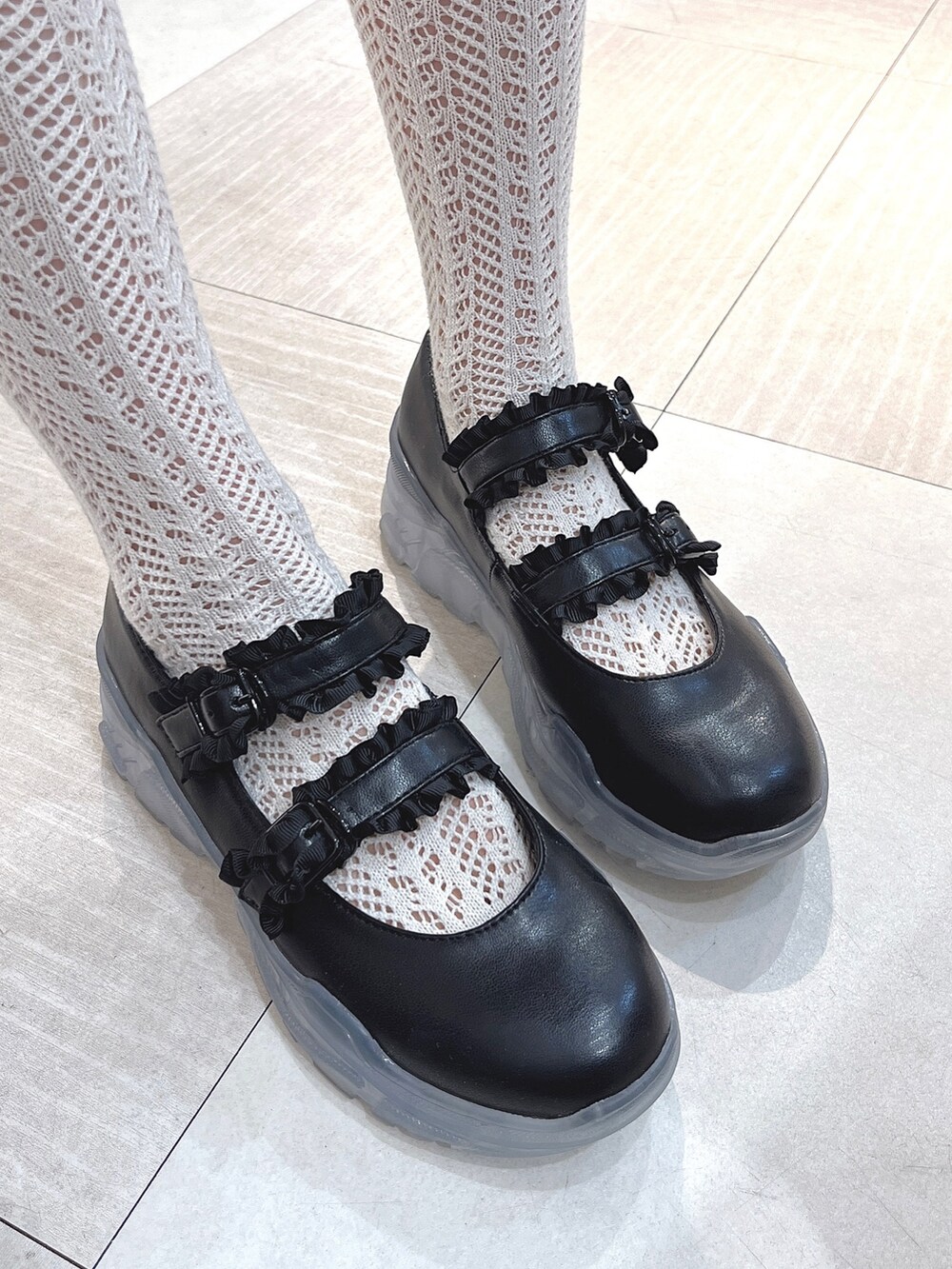 ホワイト系のカーディガン/ボレロ、ブラック系のデニムスカート、ブラック系のスニーカーを着用したレディースの冬コーディネートの10枚目の写真