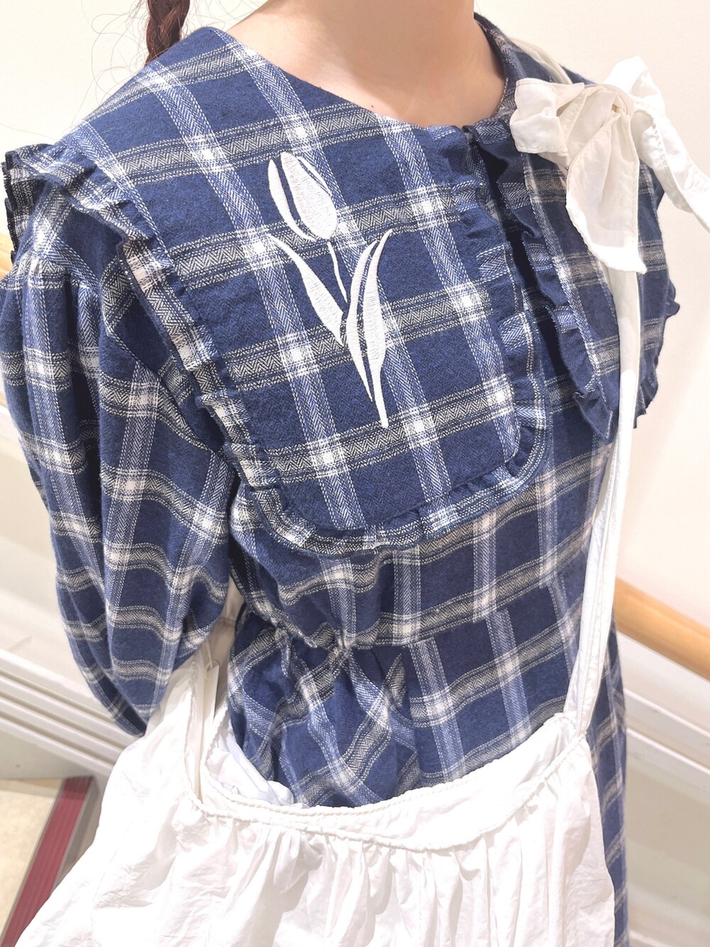 ブルー系のチェスターコート、ブルー系のワンピース、ホワイト系のショルダーバッグを着用したレディースの冬コーディネートの8枚目の写真