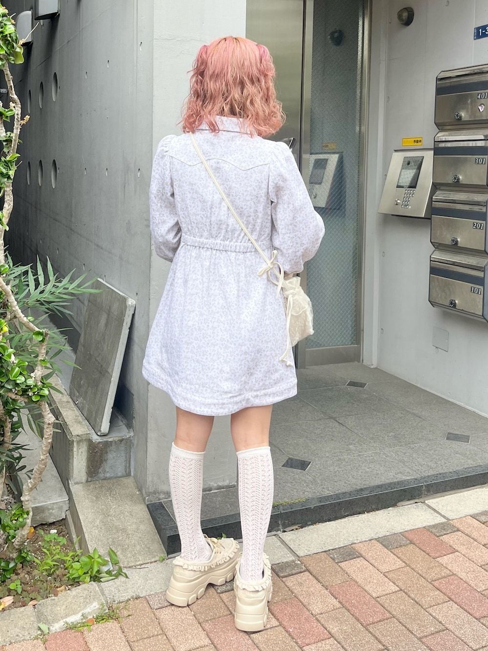 ホワイト系のワンピース、ホワイト系のショルダーバッグ、ベージュ系のローファーを着用したレディースの夏コーディネートの3枚目の写真