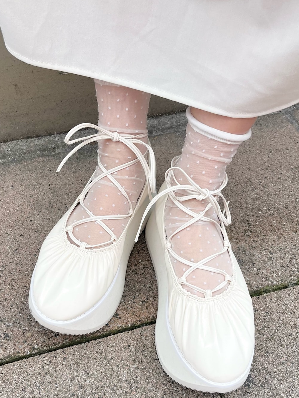 ホワイト系のワンピース、ブルー系のバックパック/リュック、ホワイト系のバレエシューズを着用したレディースの春コーディネートの10枚目の写真