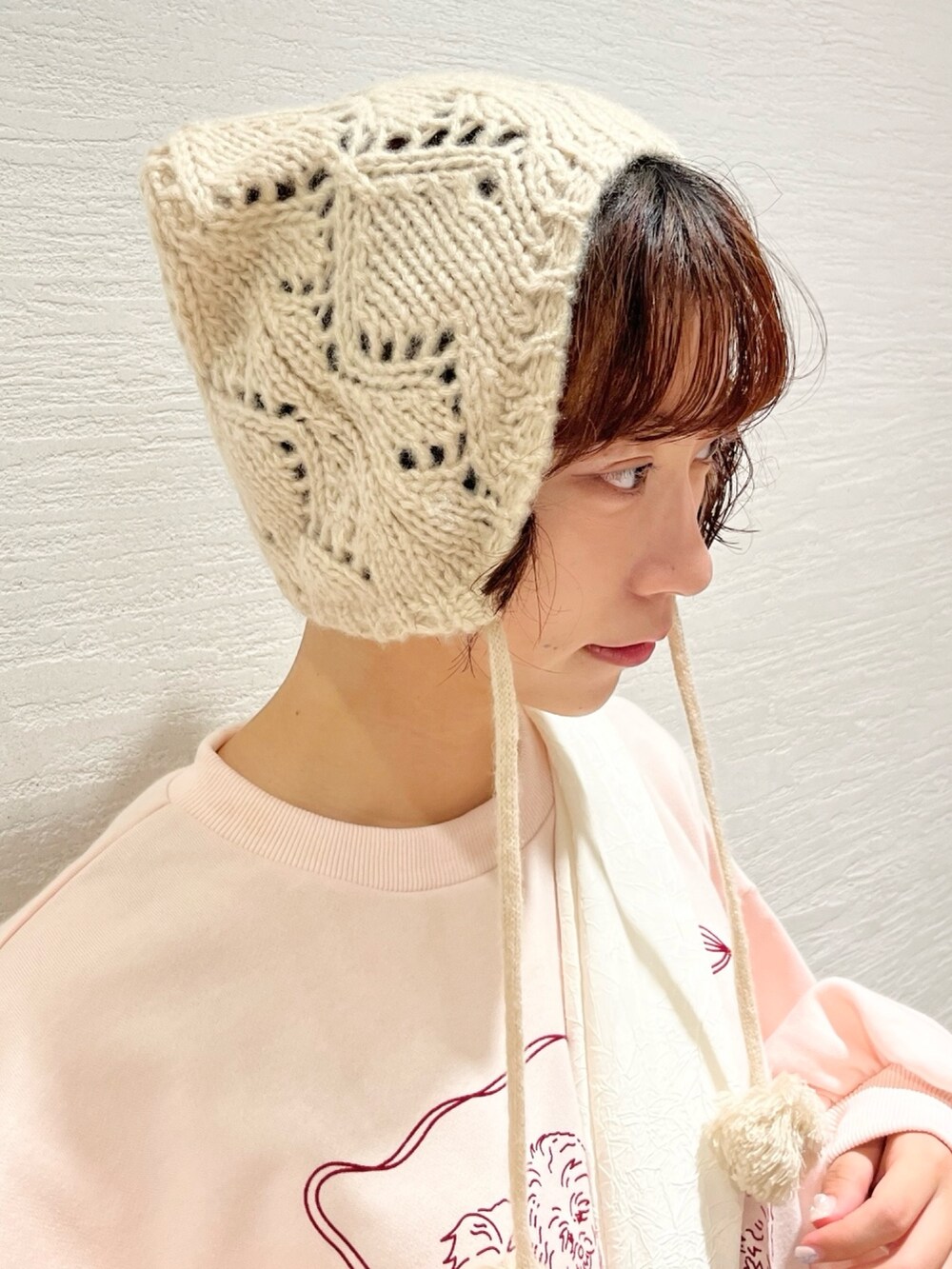 ピンク系のスウェット、ベージュ系のスカート、ホワイト系のトートバッグを着用したレディースの秋コーディネートの8枚目の写真