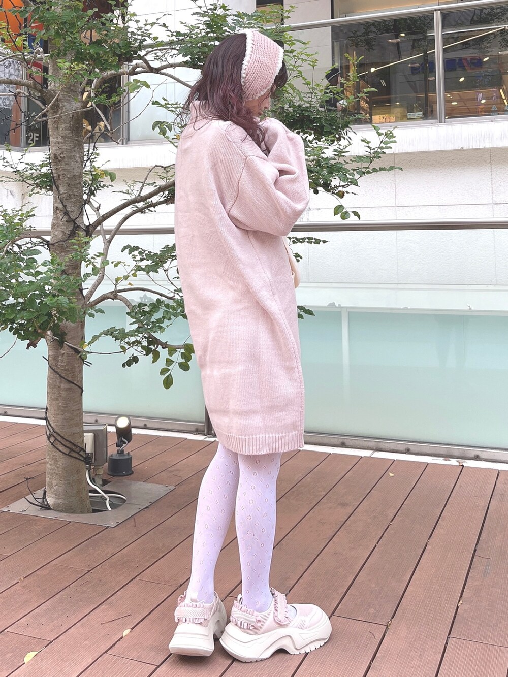 ピンク系のワンピース、ピンク系のスニーカー、ピンク系のイヤーマフを着用したレディースの秋コーディネートの3枚目の写真