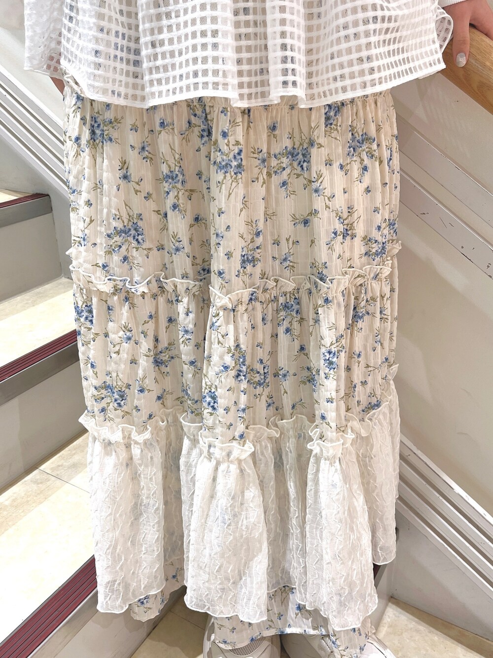 ホワイト系のスウェット、ブルー系のスカート、ホワイト系のスニーカーを着用したレディースの冬コーディネートの9枚目の写真